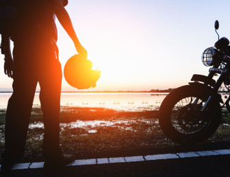 Motorradfahrer macht Paus mit Helm in der Hand